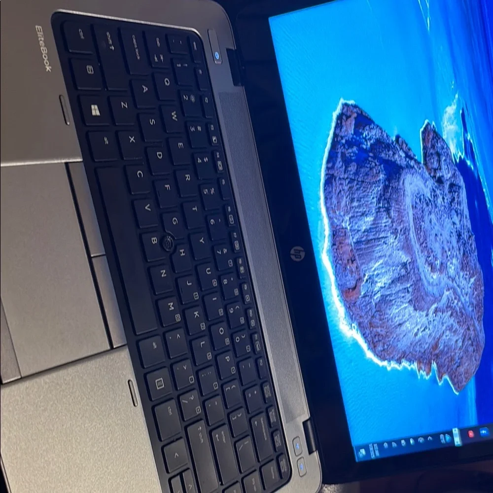 HP Silver and Black Laptop with Backlit Keyboard and Blue Display